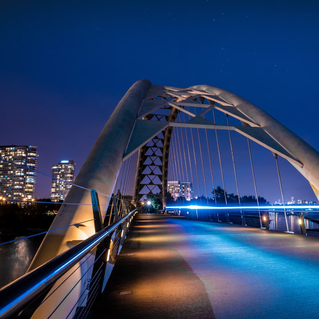 Bridge in front of a city skyline at night